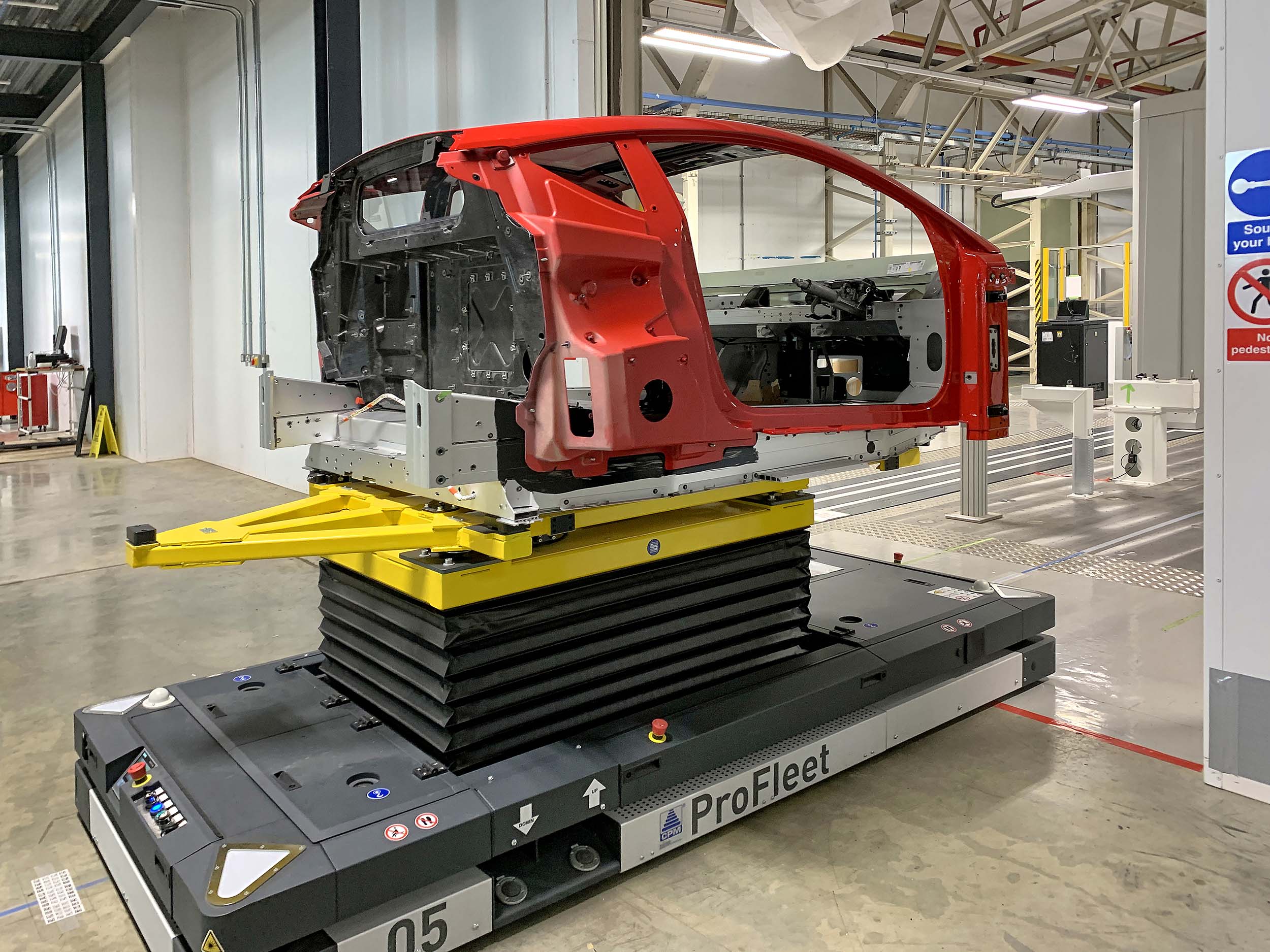 A Lotus Emira being delivered by an automated guided vehicle from the production line to    the LK CMM to undergo stage 1 inspection.