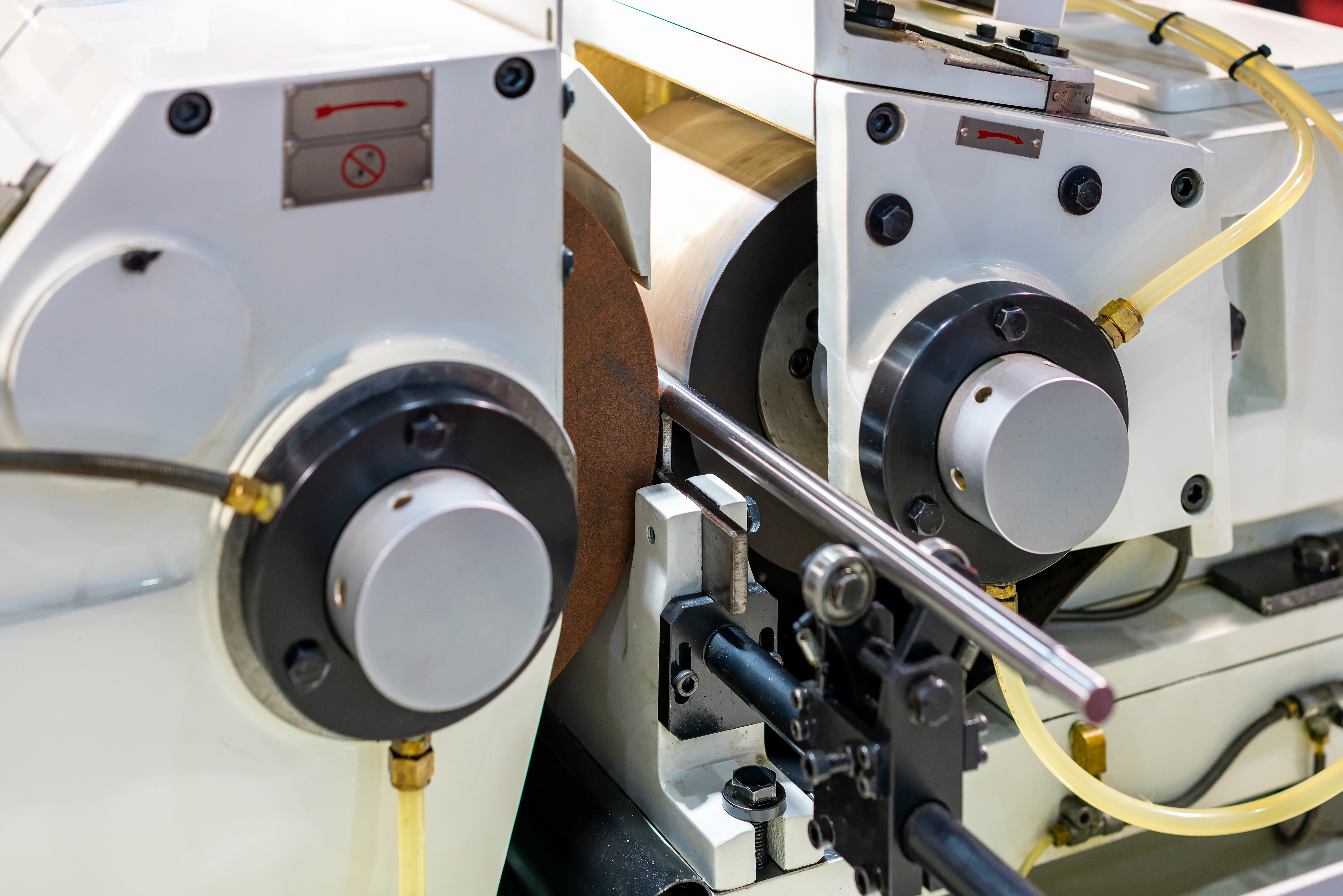 A centerless grinder is constructed with a grinding wheel mounted in a stationary housing on one side of the machine with a work rest and regulating wheel opposite the grinding wheel.