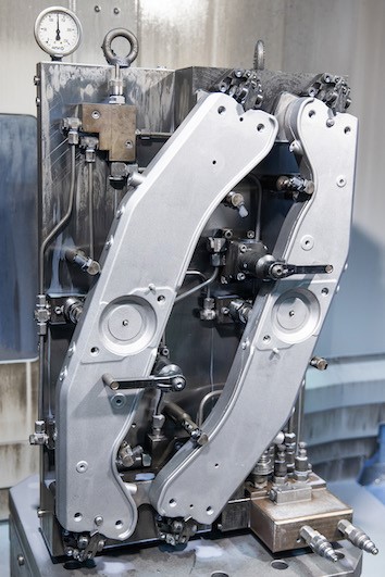 The fixtures include a base plate with pull-studs, held by the zero-point clamping modules, for each of the 15 machines.