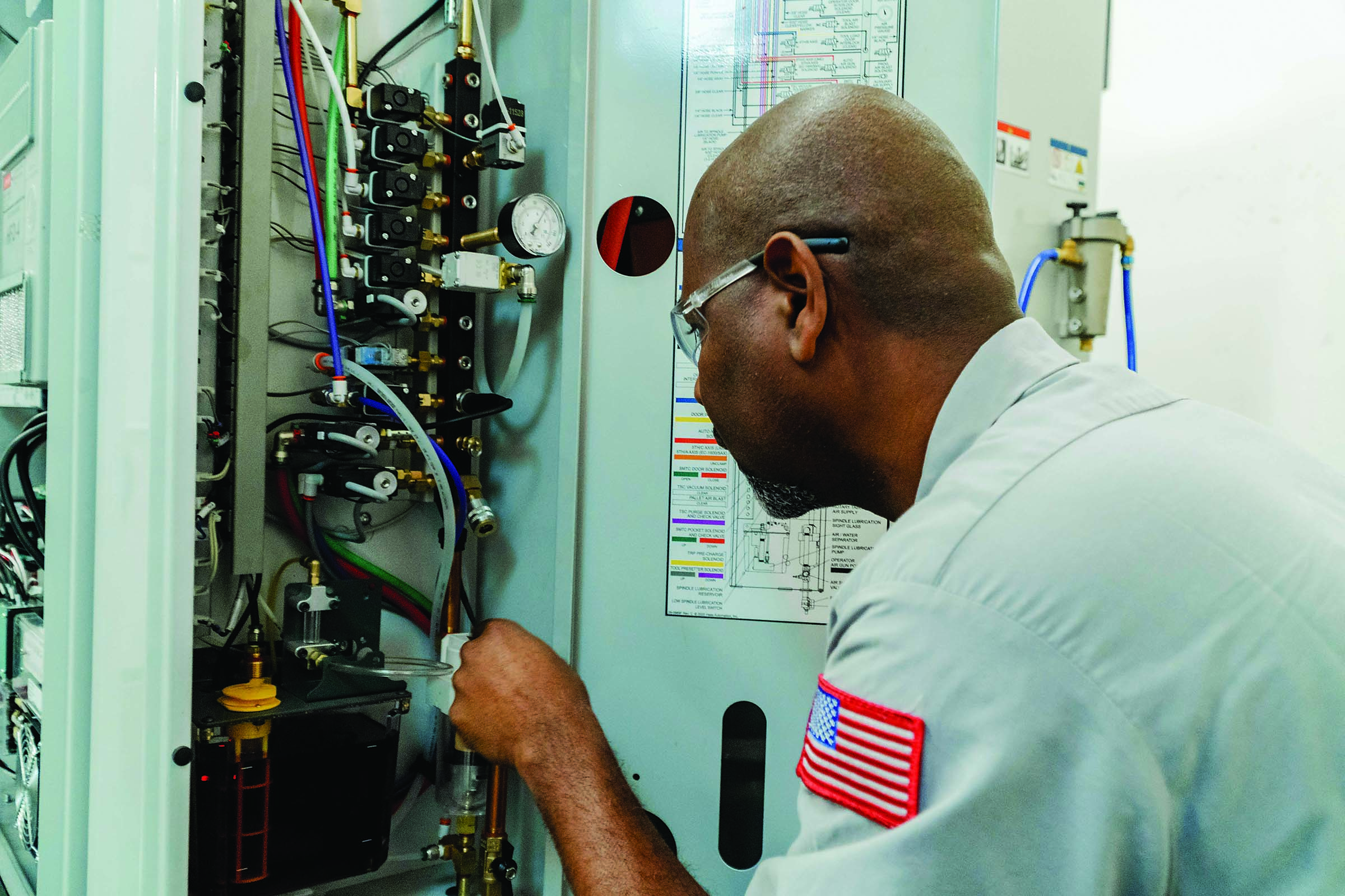 Service Engineer Orville Collins (top photo) checks the oil level for a machine spindle.