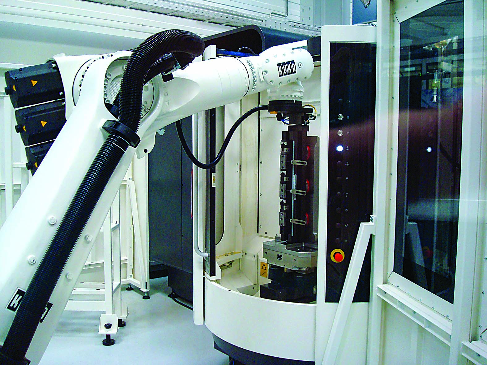 A robot places a loaded fixture on a custom tombstone fixture in the machine