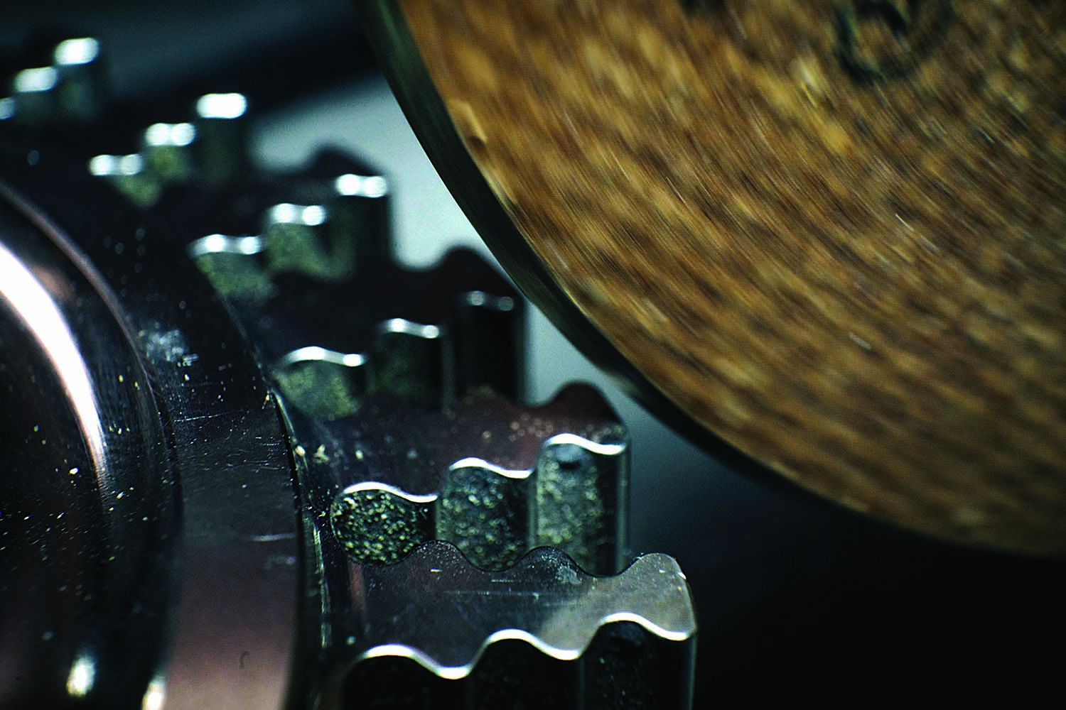 A close-up view is given of a grinding wheel deburring a fir tree rotor intended for a jet engine.