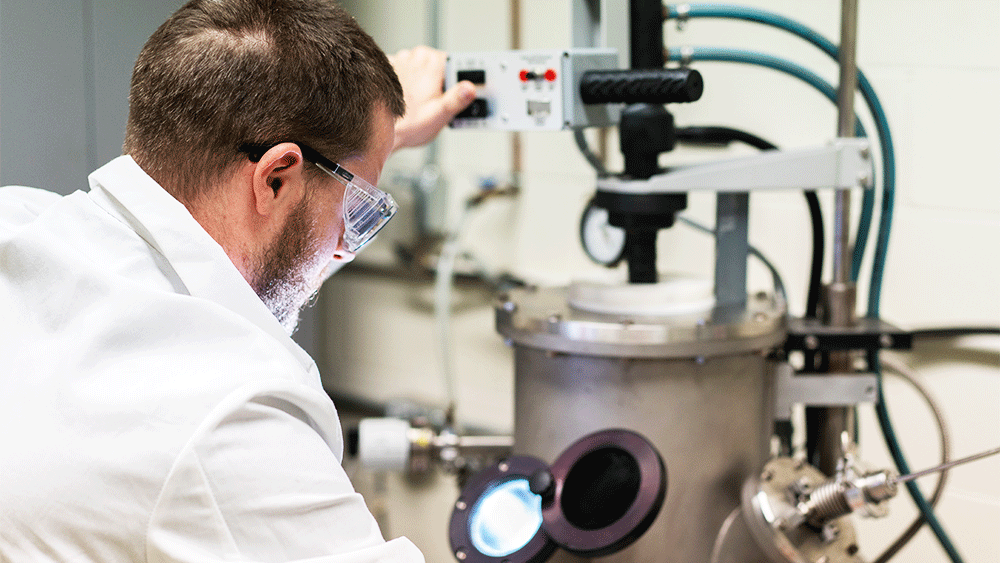 Doctoral student William Trehern operates a vacuum arc melter, a synthesis method commonly used to create high-purity alloys of various compositions.