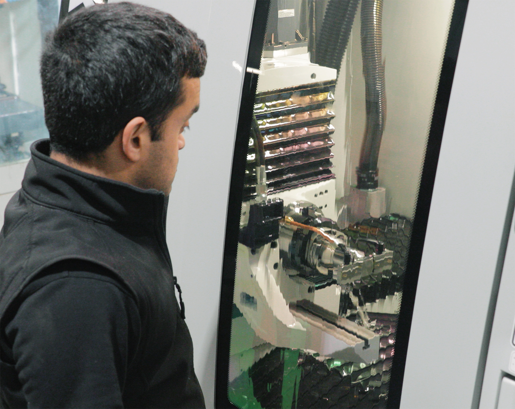 ​  Operator observing grinding process on the FX5E grinder.   ​