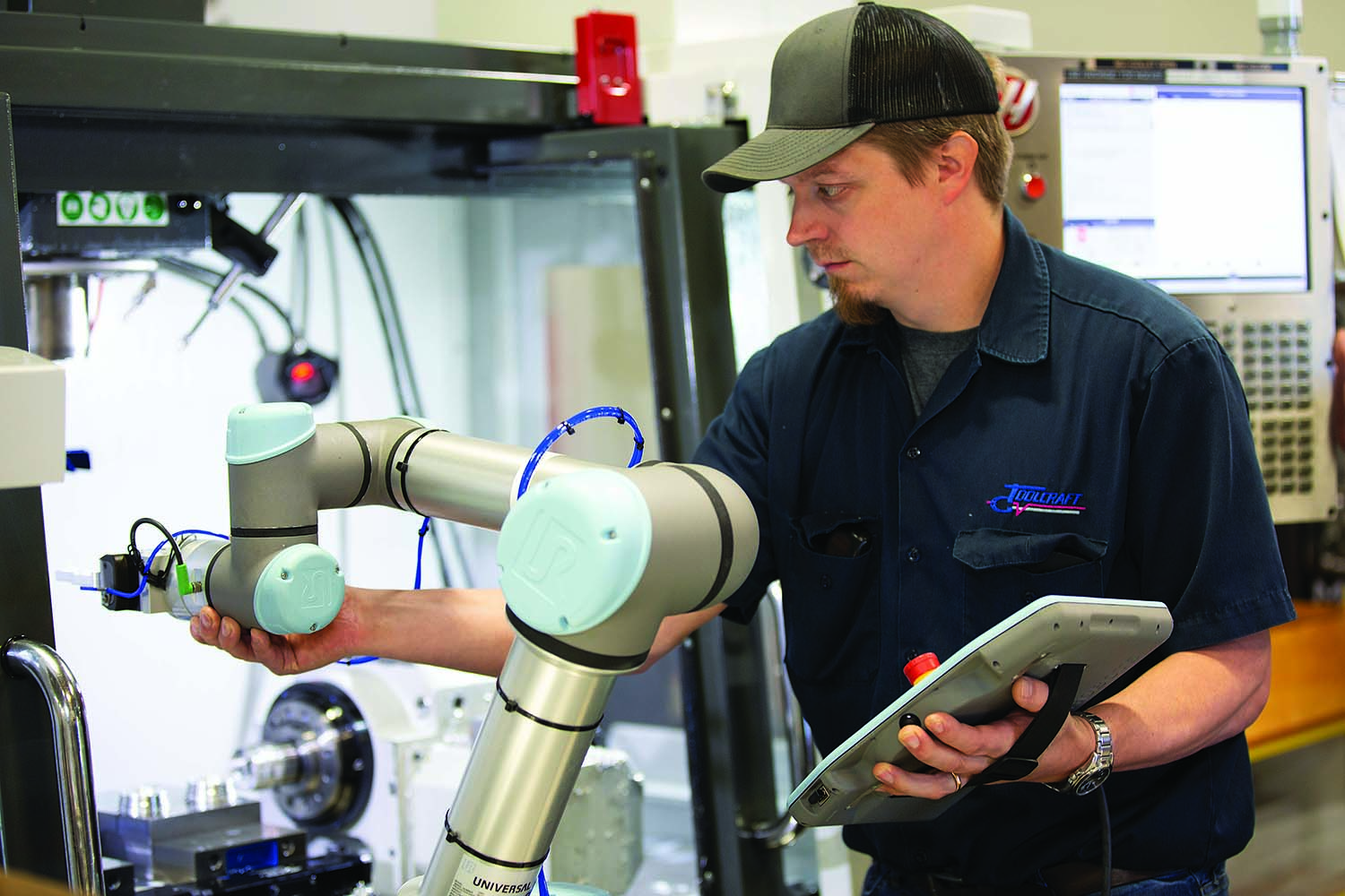 Brian Laulainen, automation engineer at Toolcraft, works with one of the shop’s UR5e cobots.