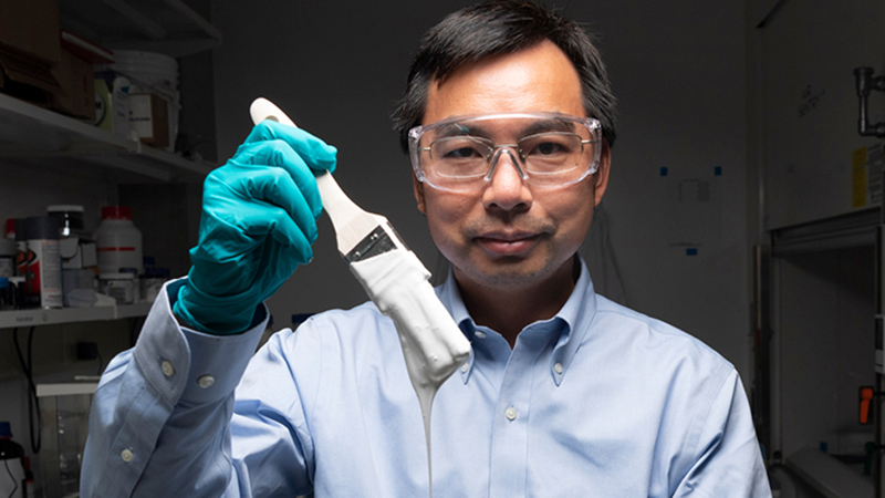  Xiulin Ruan, professor of mechanical engineering, holds up his lab’s sample of the whitest paint on record.