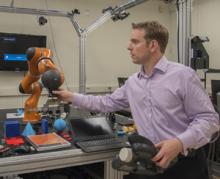 NIST engineer Jeremy Marvel adjusts a robotic arm used to study human-robot interactions. NIST engineer Jeremy Marvel adjusts a robotic arm used to study human-robot interactions.