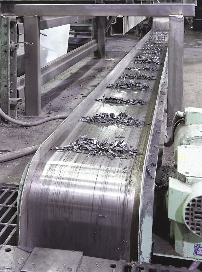 An Eriez magnetic conveyor moves punch-press scrap. Image courtesy of Eriez.