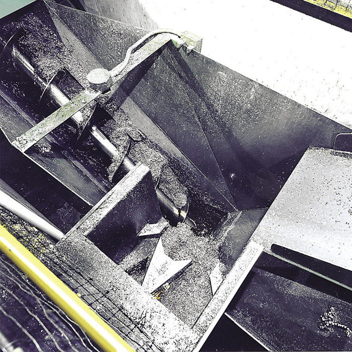 An in-floor harpoon conveyor automatically feeds a screw conveyor. Image courtesy PRAB.