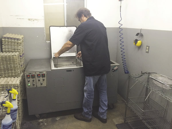 Lou Tignac, owner and president of Van’s Manufacturing, removes a basket of parts from the company’s Omegasonics Super Pro X2 ultrasonic parts cleaning machine. All images courtesy Omegasonics.
