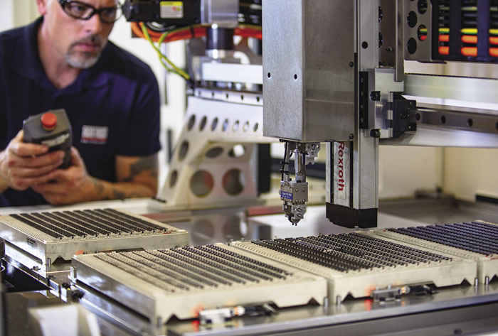 Chuck Best, CNC operator and technician at Illinois Carbide Tool, sets parameters for the Leo Peri grinder’s pick-and-place robot.