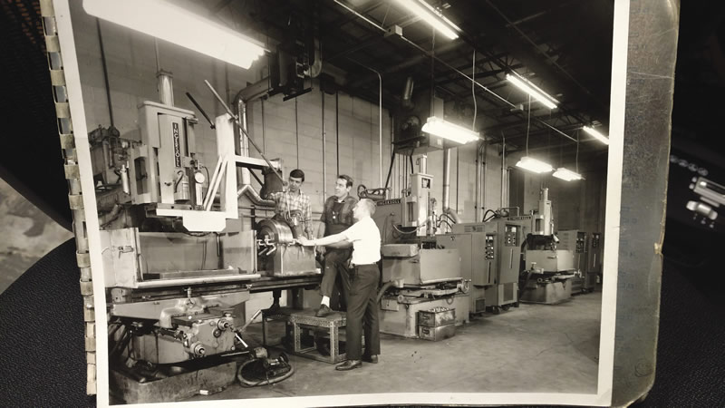 Machinists from ABET’s early days, with one of the company’s earliest sinker EDMs.
