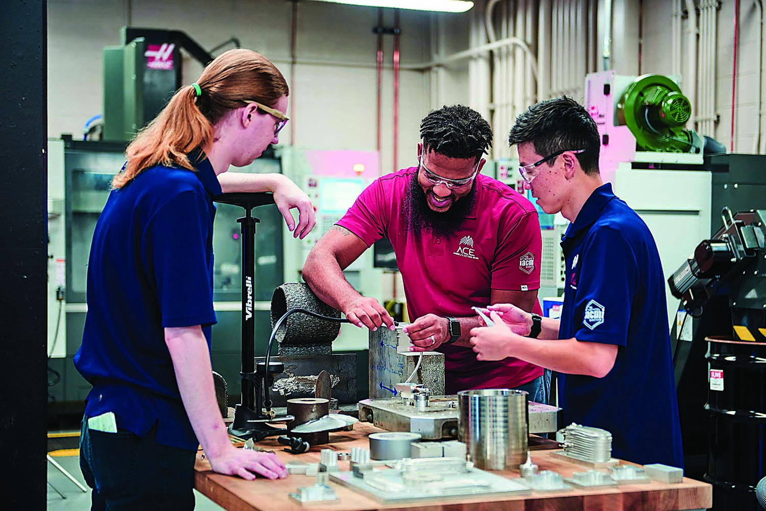 IACMI Two ACE trainers assist a student (middle).